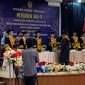 Seorang wisudawan saat menerima pengalungan kalung medali wisuda oleh seorang dosen dari STKIP Hermon Timika, pada acara Wisuda ke-V Sarjana S1 STKIP Hermon Timika di Hotel Cartenz Timika, Selasa (29/7/2025). (Foto: Galeri Papua/Ahmad). 