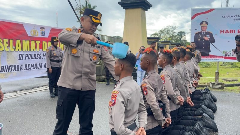 Momen Kapolres Mimika menyiram air bunga sebagai tanda penerimaan para Bintara Remaja angkatan 52 di Mapolres Mimika, di Jalan Agimuga, Mile 32, Mimika, Papua Tengah. (Foto: Istimewa/Humas Polres Mimika)