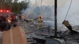 Seorang petugas Damkar terlihat sedang menarik selang air mendekati sumber api untuk melakukan pemadaman pada peristiwa kebakaran 18 unit kios di Pelabuhan Poumako, Mimika, Papua Tengah, Senin, 4 Agustus 2025. (Foto: Istimewa)