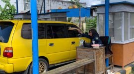 Petugas retribusi Disperindag Kabupaten Mimika sedang melayani seorang pengemudi saat akan bergegas meninggalkan portal keluar di Pasar Sentral Timika. (Foto: Galeri Papua/Ahmad)