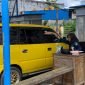 Petugas retribusi Disperindag Kabupaten Mimika sedang melayani seorang pengemudi saat akan bergegas meninggalkan portal keluar di Pasar Sentral Timika. (Foto: Galeri Papua/Ahmad)