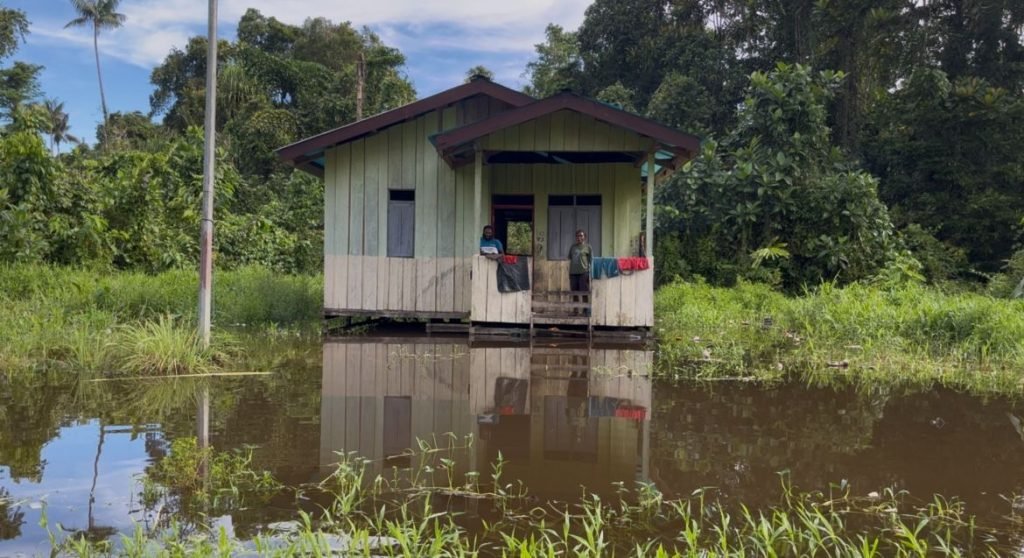 Tampak banjir di halaman depan salah satu rumah di Kampung Kamoro Jaya (kawasan penduduk Suku Amungme). (Foto: Galeri Papua/Endy Langobelen)