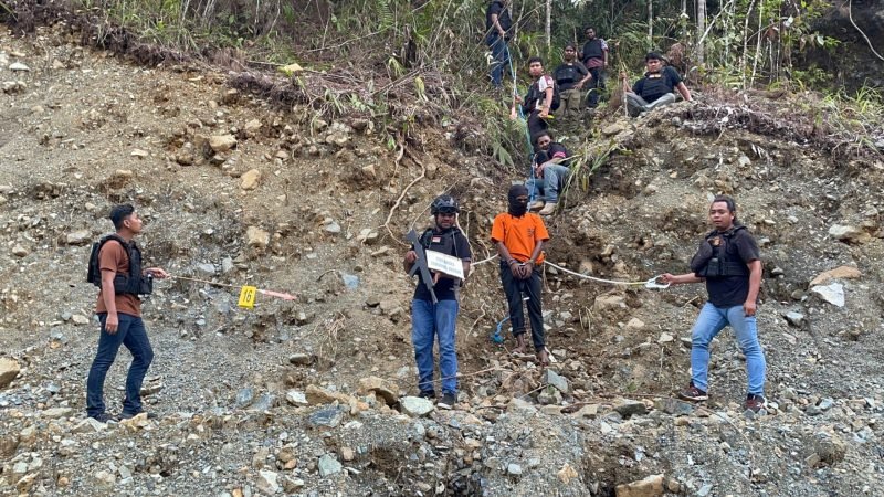 Satgas Operasi Damai Cartenz bersama Polres Nabire menggelar rekonstruksi kasus pembunuhan dua personel Brimob Yon C Nabire, Brigpol M. Arif Maulana dan Briptu Nelson C. Runaki. Rekonstruksi berlangsung di Jalan Trans Nabire–Enarotali, Distrik Siriwo, Kabupaten Nabire, Selasa (26/8/2025). (Foto: Istimewa/Satgas Humas Operasi Damai Cartenz 2025)