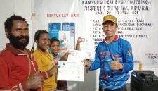 Kepala Disdukcapil Kabupaten Mimika, Slamet Sutejo, menyerahkan dokumen administrasi kependudukan kepada perwakilan masyarakat. (Foto: Disdukcapil Kabupaten Mimika)