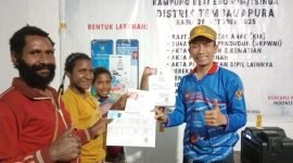 Kepala Disdukcapil Kabupaten Mimika, Slamet Sutejo, menyerahkan dokumen administrasi kependudukan kepada perwakilan masyarakat. (Foto: Disdukcapil Kabupaten Mimika)