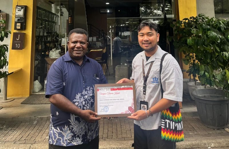 Kepala Dinas Koperasi dan UMKM Kabupaten Mimika, Samuel Yogi, menyerahkan sertifikat kepada Renso selaku Perwakilan Komunitas Timuka. (Foto: Istimewa)