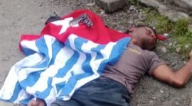Seorang pria berinisial ODG tergeletak dengan bendera bintang kejora dan korek api pistol di Kebun Sirih, Mimika, Papua Tengah, Senin (1/12/2025). (Foto: Istimewa)