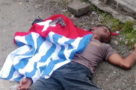 Seorang pria berinisial ODG tergeletak dengan bendera bintang kejora dan korek api pistol di Kebun Sirih, Mimika, Papua Tengah, Senin (1/12/2025). (Foto: Istimewa)