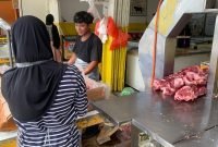 Dua orang karyawan Yuri Chiken sedang memisahkan daging yang baru dipotong. (Foto: Galeri Papua/Ahmad)