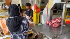 Dua orang karyawan Yuri Chiken sedang memisahkan daging yang baru dipotong. (Foto: Galeri Papua/Ahmad)