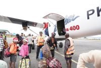 Karyawan dan keluarga tiba di Bandar Udara Enarotali di Kabupaten Paniai sedang mengeluarkan bagasi dari Pesawat Twin Otter. (Foto: Istimewa/Dokumen PTFI)