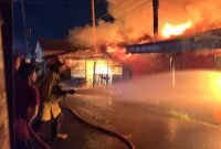 Pemadam kebakaran berupaya memadamkan api yang menghanguskan deretan rumah di Jalan Pendidikan, Jalur 1, lorong samping toko minuman keras, Kabupaten Mimika, Papua Tengah, Sabtu (20/12/2025) dini hari. (Foro: Galeri Papua/Endy Langobelen)