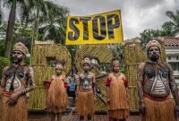 Greenpeace Indonesia menggelar aksi teater untuk memprotes Proyek Strategis Nasional (PSN) Tebu Merauke di depan kantor Kementerian Koordinator Bidang Perekonomian di Jakarta. Greenpeace mengutuk deforestasi besar-besaran yang terjadi di Merauke akibat proyek tebu ini; setidaknya 560.000 hektar hutan telah hancur di Merauke, Papua Selatan. (Foto: Istimewa/Dok. Greenpeace - Jurnasyanto Sukarno)