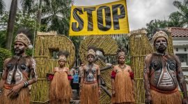 Greenpeace Indonesia menggelar aksi teater untuk memprotes Proyek Strategis Nasional (PSN) Tebu Merauke di depan kantor Kementerian Koordinator Bidang Perekonomian di Jakarta. Greenpeace mengutuk deforestasi besar-besaran yang terjadi di Merauke akibat proyek tebu ini; setidaknya 560.000 hektar hutan telah hancur di Merauke, Papua Selatan. (Foto: Istimewa/Dok. Greenpeace - Jurnasyanto Sukarno)