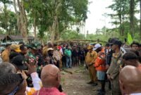 Para pejabat dari Pemkab Mimika, Pemkab Puncak, Forkopimda, dan masyarakat dari dua kubu berkonflik, sedang hening dalam doa usai ritual patah panah untuk mengakhiri konflik Kwamki Narama, Senin (12/1/2026). (Foto: Galeri Papua/Ahmad)