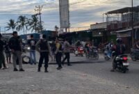 Aparat kepolisian membersihkan arang ban yang dibakar oleh para pendulang di Jalan Leo Mamiri Timika, Selasa (17/2/2026). (Foto: Galeri Papua/Ahmad)