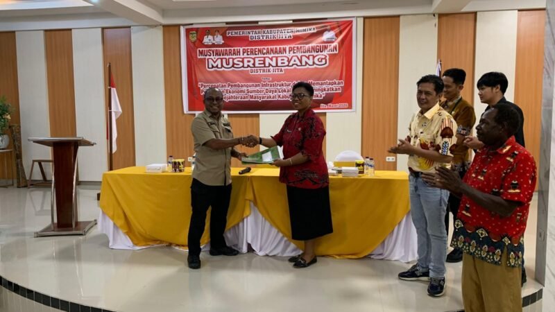 Momen penyerahan hasil Musrembang dalam bentuk dokumen tertulis oleh Kepala Distrik Jita, Suto Rontini (kiri), kepada Kepala Bidang Pemerintahan dan Pembangunan Manusia Bappeda Mimika, Regina Wenda, usai kegiatan Musrembang di Ballroom Kanguru Hotel Timika, Jumat (6/3/2026). (Foto: Galeri Papua/Ahmad)