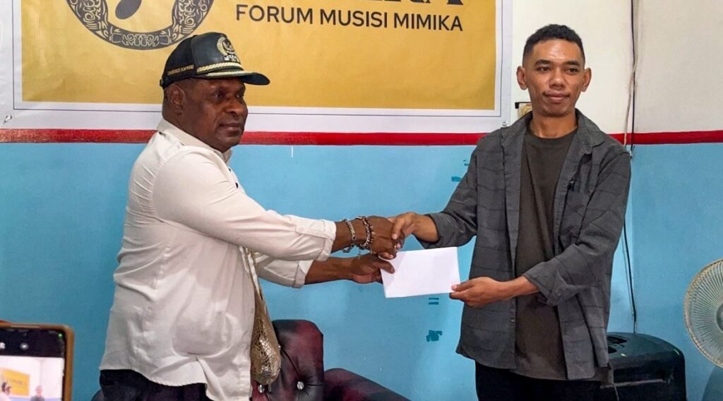 Anggota Komisi III DPRK Mimika, Dominggus Kapiyau, memberikan bantuan kepada Forum Musisi Mimika (FOMIKA). (Foto: Galeri Papua/Endy Langobelen)