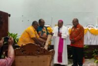 Pemukulan tifa oleh Wakil Bupati, Emanuel Kemong, Uskup Bernardus Bofitwos Baru, dan perwakilan Pt Freeport Indonesia, Nathan Kum, menandakan kegiatan lokakarya yang berlangsung selama 3 hari resmi ditutup di Aula Bobaigo, Keuskupan, Jl.Cendrawasih, Timika. (Foto: Galeri Papua/Kevin Kurni)