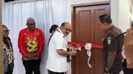 Kajati Papua, Dr. Jefferdian, melakukan pengguntingan pita sebagai tanda diresmikannya dua unit rumah Kejari Mimika yang merupakan hibah dari Pemkab Mimika senilai Rp1,5 miliar, Sabtu (18/4/2026). (Foto: Galeri Papua/Endy Langobelen)