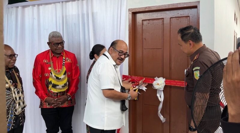 Kajati Papua, Dr. Jefferdian, melakukan pengguntingan pita sebagai tanda diresmikannya dua unit rumah Kejari Mimika yang merupakan hibah dari Pemkab Mimika senilai Rp1,5 miliar, Sabtu (18/4/2026). (Foto: Galeri Papua/Endy Langobelen)
