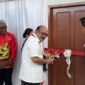 Kajati Papua, Dr. Jefferdian, melakukan pengguntingan pita sebagai tanda diresmikannya dua unit rumah Kejari Mimika yang merupakan hibah dari Pemkab Mimika senilai Rp1,5 miliar, Sabtu (18/4/2026). (Foto: Galeri Papua/Endy Langobelen)