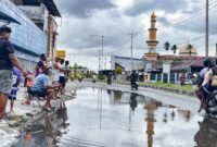 Aksi mancing oleh warga sebagai bentuk kritik terhadap genangan air yang selalu terjadi di Jalan Ahmad Yani, tepat di depan Bengkel Surabaya Motor, Kelurahan Kebun Sirih, Distrik Mimika Baru, Kabupaten Mimika, Papua Tengah, Minggu (19/4/2026). (Foto: Galeri Papua/Endy Langobelen)