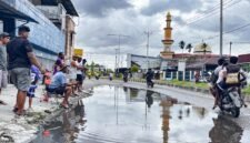 Aksi mancing oleh warga sebagai bentuk kritik terhadap genangan air yang selalu terjadi di Jalan Ahmad Yani, tepat di depan Bengkel Surabaya Motor, Kelurahan Kebun Sirih, Distrik Mimika Baru, Kabupaten Mimika, Papua Tengah, Minggu (19/4/2026). (Foto: Galeri Papua/Endy Langobelen)