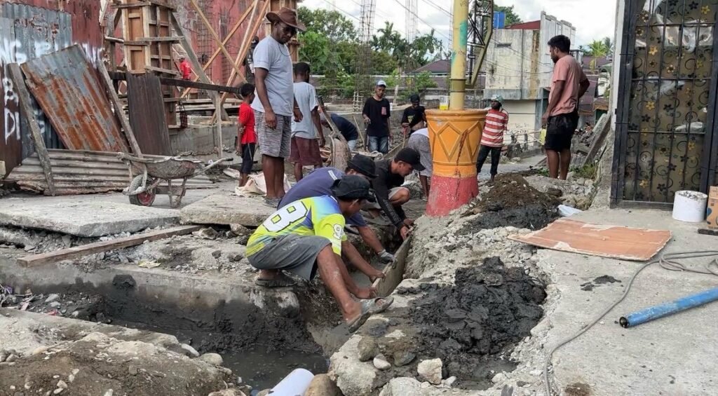 Warga belakang Bengkel Surabaya Motor, Jalan Ahmad Yani, Kelurahan Kebun Sirih, Distrik Mimika Baru, Kabupaten Mimika, Papua Tengah, bergotong royong melakukan penanganan awal perbaikan drainase, Selasa (21/4/2026). (Foto: Galeri Papua/Endy Langobelen)