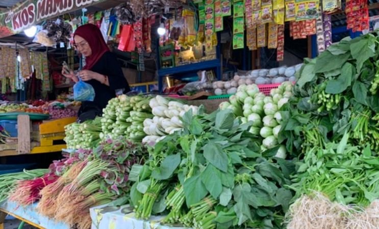 Mama Rio, pedagang di Pasar Sentral Timika sedang melayani seorang pembeli, di lapak miliknya, Rabu (20/5/2026). (Foto: Galeri Papua/Ahmad)