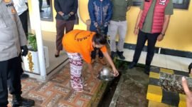 Seorang tersangka menuangkan barang bukti sabu yang telah dilarutkan ke dalam air panas pada kegiatan pemusnahan barang bukti narkotika di Mako Polres Mimika, Jalan Agimuga, Mile 32, Mimika, Papua Tengah, Kamis (4/6/2026). (Foto: Galeri Papua/Ahmad)
