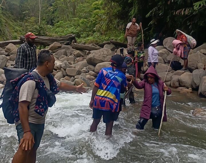 Rombongan tenaga kesehatan Puskesmas Aroanop menyebrangi salah satu dari 12 sungai dalam perjalanan dari Kampung Ainggogin ke Kampung Banti, Distrik Tembagapura, Kabupaten Mimika, Papua Tengah, Rabu (3/6/2026). (Foto: Istimewa/Dok. Puskesmas Aroanop)