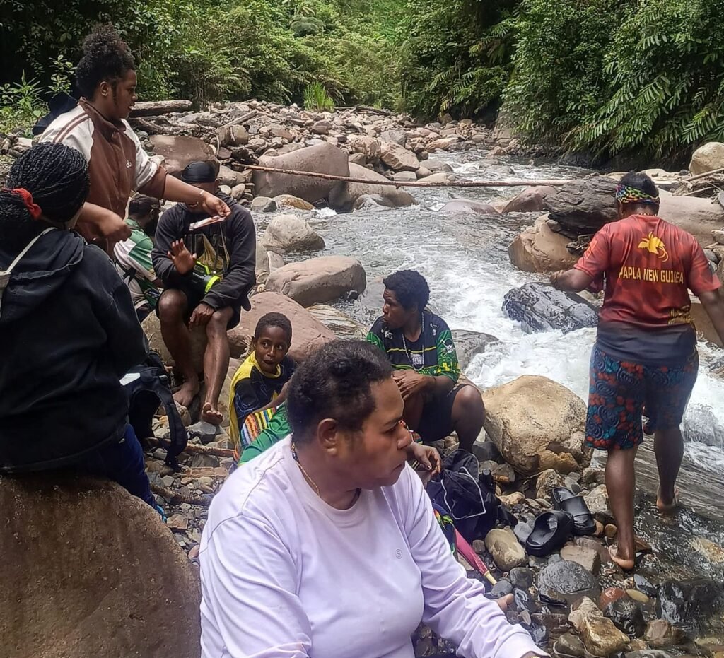 Rombongan tenaga kesehatan Puskesmas Aroanop beristirahat di tepi sungai dalam perjalanan 12 jam dari Kampung Ainggogin ke Kampung Banti, Distrik Tembagapura, Kabupaten Mimika, Papua Tengah, Rabu (3/6/2026). (Foto: Istimewa/Dok. Puskesmas Aroanop)