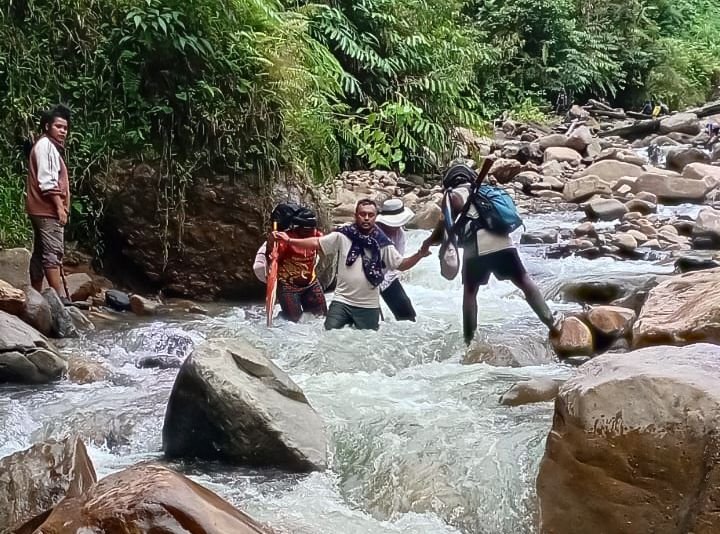 Rombongan tenaga kesehatan Puskesmas Aroanop menyebrangi salah satu dari 12 sungai dalam perjalanan dari Kampung Ainggogin ke Kampung Banti, Distrik Tembagapura, Kabupaten Mimika, Papua Tengah, Rabu (3/6/2026). (Foto: Istimewa/Dok. Puskesmas Aroanop)