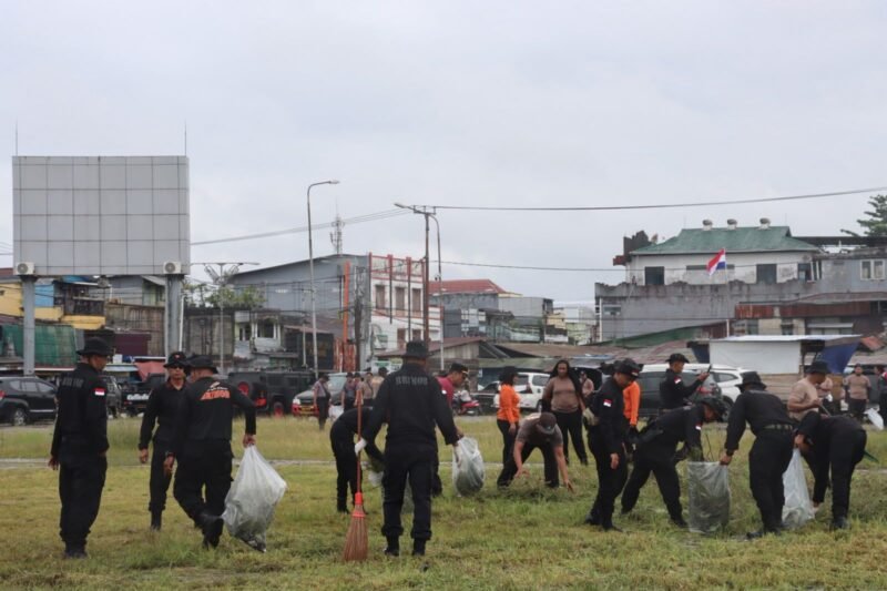 Personel gabungan Polres Mimika dan Brimob Yon B Pelopor melaksanakan aksi pembersihan lingkungan dalam Gerakan Indonesia ASRI di Lapangan Eks Pasar Lama, Mimika, Papua Tengah, Jumat (12/6/2026). (Foto: Istimewa)