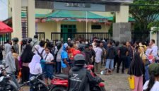 Ratusan orang tua dan siswa yang berdiri mengantre menunggu giliran di depan pagar SMANSA Mimika, Senin (22/6/2026). (Foto: Galeri Papua/Ahmad)