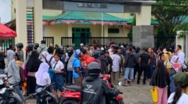 Ratusan orang tua dan siswa yang berdiri mengantre menunggu giliran di depan pagar SMANSA Mimika, Senin (22/6/2026). (Foto: Galeri Papua/Ahmad)
