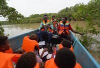 David Nataime seorang Pemandu Tour Ekowisata Mangrove Pigapi Sedang menjelaskan manfaat Tumbuhan Ndoa atau dalam bahasa indonesia disebut Jeruju (Acanthus ilicifolius) yang digunakan sebagai bahan baku utama Minuman Ndoa kepada murid dan guru SD Negeri Pigapu. (Foto: Istimewa)