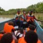 David Nataime seorang Pemandu Tour Ekowisata Mangrove Pigapi Sedang menjelaskan manfaat Tumbuhan Ndoa atau dalam bahasa indonesia disebut Jeruju (Acanthus ilicifolius) yang digunakan sebagai bahan baku utama Minuman Ndoa kepada murid dan guru SD Negeri Pigapu. (Foto: Istimewa)