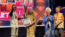 Ketua Dekranasda Kabupaten Deiyai yang juga Ketua TP-PKK Deiyai, Fransina Rumbiak Mote, menerima piagam dan piala juara umum TIFA 2026 yang diserahkan oleh Joko Suharbowo selaku Ketua Tim Wilayah Indonesia Timur untuk Event Daerah pada Kementerian Pariwisata RI. (Foto: Galeri Papua/Endy Langobelen)