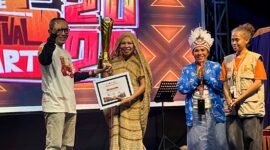 Ketua Dekranasda Kabupaten Deiyai yang juga Ketua TP-PKK Deiyai, Fransina Rumbiak Mote, menerima piagam dan piala juara umum TIFA 2026 yang diserahkan oleh Joko Suharbowo selaku Ketua Tim Wilayah Indonesia Timur untuk Event Daerah pada Kementerian Pariwisata RI. (Foto: Galeri Papua/Endy Langobelen)