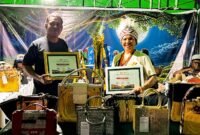 Owner Brand Ticha, Beatrix Antoneta Manggo, bersama rekan berada di stan pamerannya sambil menunjukkan piagam dan piala juara I TIFA 2026. (Foto: Galeri Papua/Endy Langobelen)