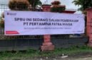Spanduk berisikan informasi mengenai sanksi terhadap SPBU SP2 Mimika dipasang pada bagian depan pagar. (Foto: Galeri Papua/Ahmad)