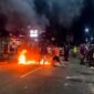 Keluarga korban melakukan aksi spontan dengan memalang dua badan Jalan Cenderawasih di depan Hotel 66 sekitar pukul 22.54 WIT. Mereka membakar ban bekas dan karton di tengah jalan sebagai bentuk protes sekaligus mendesak polisi segera menangkap para pelaku. (Foto: Istimewa/Humas Polres Mimika)