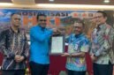 Pelaksana Tugas (Plt) Kepala BRIDA Kabupaten Mimika, Darius Sabon Rain (kameja biru), berjabat tangan dengan Kakanwil Kemenkum Papua, Anthonius Ayorbaba dalam seremoni penyerahan sertifikat Hak Kekayaan Intelektual, yang mana BRIDA menjadi satu-satunya OPD pertama di Mimika yang mendaftarkan logonya untuk mendapat payung hukum HKI. (Foto: Galeri Papua/Ahmad)