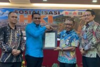 Pelaksana Tugas (Plt) Kepala BRIDA Kabupaten Mimika, Darius Sabon Rain (kameja biru), berjabat tangan dengan Kakanwil Kemenkum Papua, Anthonius Ayorbaba dalam seremoni penyerahan sertifikat Hak Kekayaan Intelektual, yang mana BRIDA menjadi satu-satunya OPD pertama di Mimika yang mendaftarkan logonya untuk mendapat payung hukum HKI. (Foto: Galeri Papua/Ahmad)