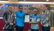 Pelaksana Tugas (Plt) Kepala BRIDA Kabupaten Mimika, Darius Sabon Rain (kameja biru), berjabat tangan dengan Kakanwil Kemenkum Papua, Anthonius Ayorbaba dalam seremoni penyerahan sertifikat Hak Kekayaan Intelektual, yang mana BRIDA menjadi satu-satunya OPD pertama di Mimika yang mendaftarkan logonya untuk mendapat payung hukum HKI. (Foto: Galeri Papua/Ahmad)
