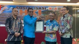 Pelaksana Tugas (Plt) Kepala BRIDA Kabupaten Mimika, Darius Sabon Rain (kameja biru), berjabat tangan dengan Kakanwil Kemenkum Papua, Anthonius Ayorbaba dalam seremoni penyerahan sertifikat Hak Kekayaan Intelektual, yang mana BRIDA menjadi satu-satunya OPD pertama di Mimika yang mendaftarkan logonya untuk mendapat payung hukum HKI. (Foto: Galeri Papua/Ahmad)