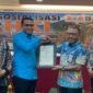 Pelaksana Tugas (Plt) Kepala BRIDA Kabupaten Mimika, Darius Sabon Rain (kameja biru), berjabat tangan dengan Kakanwil Kemenkum Papua, Anthonius Ayorbaba dalam seremoni penyerahan sertifikat Hak Kekayaan Intelektual, yang mana BRIDA menjadi satu-satunya OPD pertama di Mimika yang mendaftarkan logonya untuk mendapat payung hukum HKI. (Foto: Galeri Papua/Ahmad)