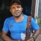 Simson Samin memegang patung yang merupakan hasil pahatannya. (Foto: Galeri Papua/Kevin Kurni)